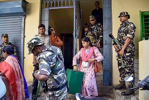 Polling officials, accompanied by Central security personnel, collect votes from elderly voters at their homes under a special facility for those unable to visit polling booths, in Siliguri.