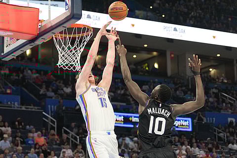 Oklahoma City Thunder center Branden Carlson (15) goes after a rebound over Phoenix Suns center Khaman Maluach (10) during the second half of an NBA basketball game in Oklahoma City. 
