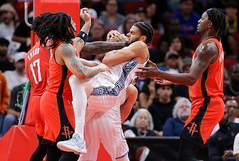 Memphis Grizzlies guard Rayan Rupert, center with ball, battles to keep a rebound between Houston Rockets forward Tari Eason, guard JD Davison, left, and forward Dorian Finney-Smith, right, during the first half of an NBA basketball game in Houston.