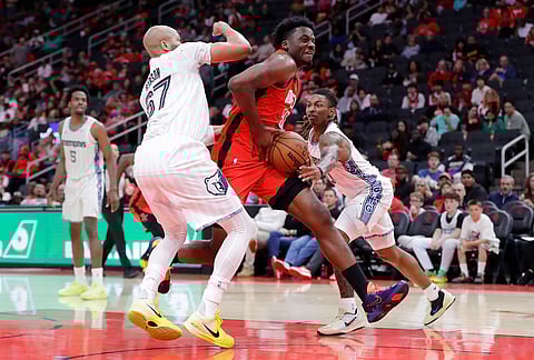 Houston Rockets center Clint Capela, center, drives between Memphis Grizzlies forward Taj Gibson (67) and guard Javon Small, right, during the second half of an NBA basketball game in Houston. 