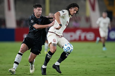Williams Riveros of Peru's Universitario, right, is challenged by Nicolas Johansen of Chile's Coquimbo Unido during a Copa Libertadores Group B soccer match in Lima, Peru.