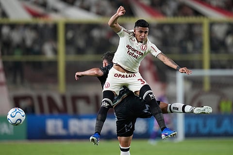 Cesar Inga of Peru's Universitario, front, and Nicolas Johansen of Chile's Coquimbo Unido battle for the ball during a Copa Libertadores Group B soccer match in Lima, Peru.