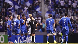 (AP Photo/Eduardo Verdugo) : Referee Ivan Barton suspends the match due to discriminatory chants from the crowd during a CONCACAF Champions Cup quarterfinal second leg soccer match between Mexico's Cruz Azul and the United States' Los Angeles FC in Puebla, Mexico, Tuesday, April 14, 2026.