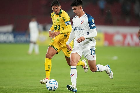Gabriel Villamil of Ecuador's Liga Deportiva Universitaria dribbles chased by Lucas Mugni of Brazil's Mirassol during a Copa Libertadores Group G soccer match in Quito, Ecuador.