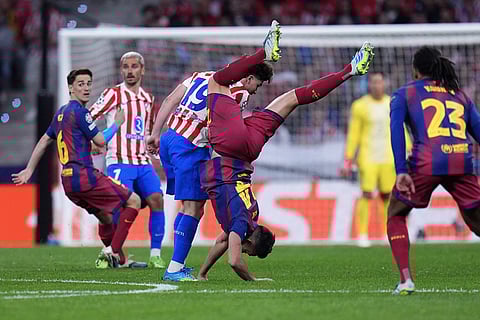 Barcelona's Eric Garcia, center right, and Atletico Madrid's Julian Alvarez challenge for the ball during the Champions League quarterfinal second leg soccer match between Atletico Madrid and Barcelona in Madrid, Spain.