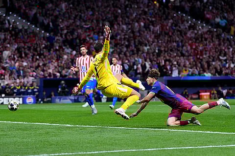 Atletico Madrid's goalkeeper Juan Musso, left, makes a save in front of Barcelona's Fermin Lopez during the Champions League quarterfinal second leg soccer match between Atletico Madrid and Barcelona in Madrid, Spain.