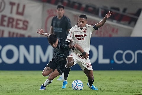 Andy Polo of Peru's Universitario, right, and Benjamin Chandia of Chile's Coquimbo Unido battle for the ball during a Copa Libertadores Group B soccer match in Lima, Peru.