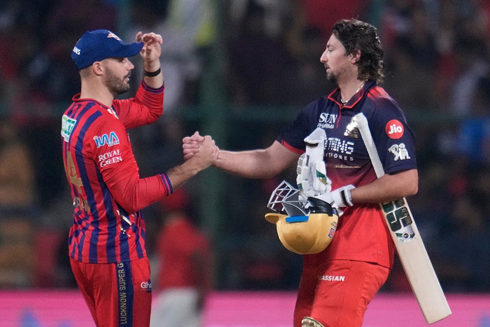 Royal Challengers Bengaluru's Tim David, right, shake hands with Lucknow Super Giants' Aiden Markram at the end of the Indian Premier League cricket match against Lucknow Super Giants in Bengaluru, India. - | Photo: AP/Aijaz Rahi