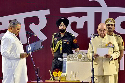 Bihar Governor Syed Ata Hasnain, right, administers the oath of office to JD(U) leader Vijay Kumar Choudhary, left, during his swearing-in ceremony as member of the Council of Ministers, at Lok Bhawan, in Patna.