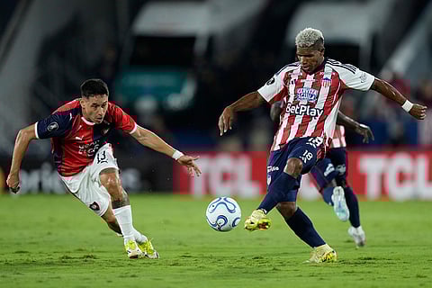 Angel Benitez of Paraguay's Cerro Porteño, left, and Kevin Perez of Colombia's Junior vie for the ball during a Copa Libertadores soccer match in Asuncion, Paraguay.