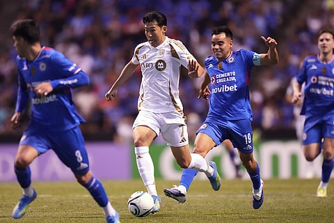 Son Heung-Min of the United States' Los Angeles FC, center, dribbles the ball challenged by Carlos Rodriguez of Mexico's Cruz Azul during a CONCACAF Champions Cup quarterfinal second leg soccer match in Puebla, Mexico.