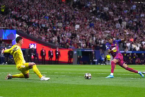 Barcelona's Lamine Yamal, right, scores the opening goal during the Champions League quarterfinal second leg soccer match between Atletico Madrid and Barcelona in Madrid, Spain.
