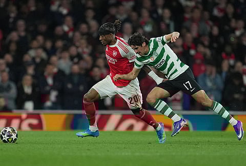Arsenal's Noni Madueke, left, and Sporting's Francisco Trincao fight for the ball during the UEFA Champions League second leg quarterfinal soccer match between Arsenal and Sporting in London, England.
