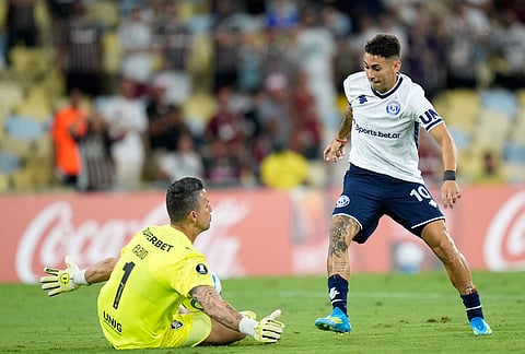 Goalkeeper Fabio of Brazil's Fluminense blocks a goal attempt by Matias Fernadez of Argentina's Independiente Rivadavia during a Copa Libertadores Group C soccer match in Rio de Janeiro.