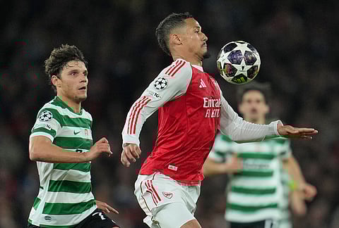 Arsenal's William Saliba, front, and Sporting's Eduardo Quaresma pfp during the UEFA Champions League second leg quarterfinal soccer match between Arsenal and Sporting in London, England.