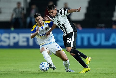Gonzalo Sandez of Argentina's Rosario Central, left, and Estiven Villalba of Paraguay's Libertad vie for the ball during a Copa Libertadores Group H soccer match in Asuncion, Paraguay.
