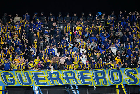 Fans of Argentina's Rosario Central cheer their team during a Copa Libertadores Group H soccer match against Paraguay's Libertad in Asuncion, Paraguay.