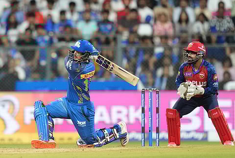 Mumbai Indians' wicketkeeper Quinton de Kock hits a six during the Indian Premier League cricket match between Mumbai Indians and Punjab Kings in Mumbai.