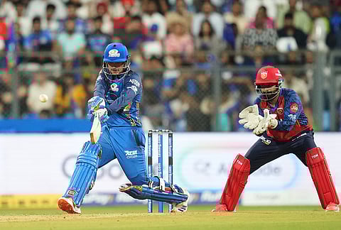 Mumbai Indians' wicketkeeper Quinton de Kock hits a boundary during the Indian Premier League cricket match between Mumbai Indians and Punjab Kings in Mumbai.
