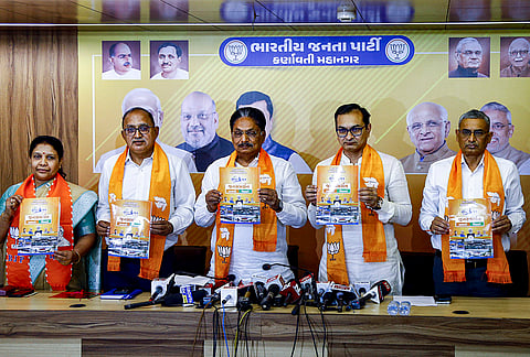 Gujarat Minister for Legislative and Parliamentary Affairs Rushikesh Patel, Center, and others release Bhartiya Janta Party (BJP) 'Sankalp Patra 2026' ahead of the Ahmedabad Municipal Corporation (AMC) elections, at BJP office, in Khanpur, Ahmedabad, Gujarat.