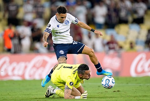 Goalkeeper Fabio of Brazil's Fluminense blocks a goal attempt by Matias Fernadez of Argentina's Independiente Rivadavia during a Copa Libertadores Group C soccer match in Rio de Janeiro.