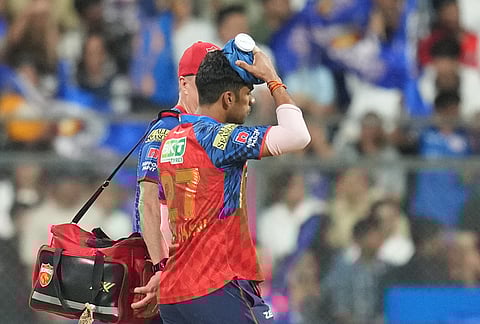 Punjab Kings' Shashank Singh leaves the field after a ball hits on his head during the Indian Premier League cricket match between Mumbai Indians and Punjab Kings in Mumbai.