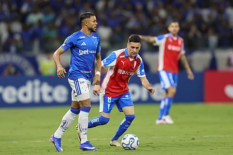 Wanderson of Brazil's Cruzeiro, left, goes with the ball followed by Fernando Zuqui of Chile's Universidad Catolica during a Copa Libertadores Group D soccer match in Belo Horizonte, Brazil.