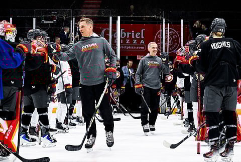 President of Finland Alexander Stubb, left, and Canada Prime Minister Mark Carney fist bump with Ottawa Charge players as they participate in an Ottawa Charge practice session at TD Place in Ottawa.