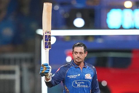 Mumbai Indians' wicketkeeper Quinton de Kock celebrates his century during the Indian Premier League cricket match between Mumbai Indians and Punjab Kings in Mumbai.