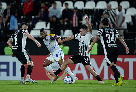 Jaminton Campaz of Argentina's Rosario Central, second left, battles for the ball with Alvaro Campuzano, left, and Thiago Fernandez of Paraguay's Libertad during a Copa Libertadores Group H soccer match in Asuncion, Paraguay.
