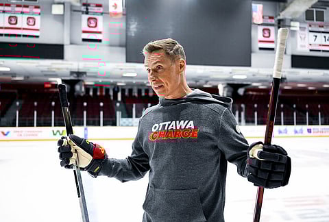President of Finland Alexander Stubb holds a pair of hockey sticks as he participates in an Ottawa Charge hockey practice session with Canada Prime Minister Mark Carney, not seen, at TD Place in Ottawa.