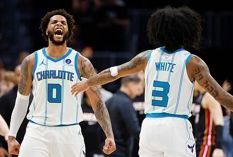 Charlotte Hornets forward Miles Bridges (0) reacts after scoring against the Miami Heat as guard Coby White looks on during the second half of an NBA play-in tournament basketball game in Charlotte, North Carolina.