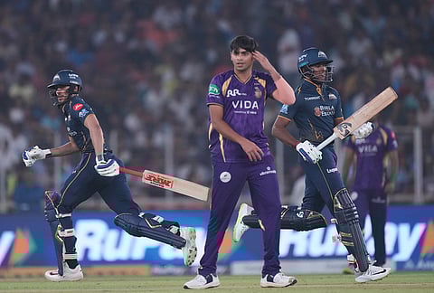 Gujarat Titans' captain Shubman Gill, left, and Sai Sudharsan run between the wickets as Kolkata Knight Riders' Kartik Tyagi, centre, looks during the Indian Premier League cricket match between Gujarat Titans and Kolkata Knight Riders in Ahmedabad.