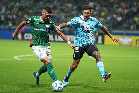 Andreas Pereira of Brazil's Palmeiras, left, is challenged by Gustavo Cazonatti of Peru's Sporting Cristal during a Copa Libertadores Group F soccer match in Sao Paulo.