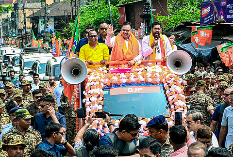 Rajasthan Chief Minister Bhajan Lal Sharma, centre, waves to the gathering during an election campaign in support of BJP candidate for Siliguri constituency, Shankar Ghosh, right, ahead of West Bengal Assembly Election, in Darjeeling district. 