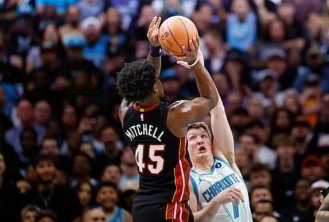 Miami Heat guard Davion Mitchell (45) shoots against Charlotte Hornets guard Kon Knueppel during the first half of an NBA play-in tournament basketball game in Charlotte, North Carolina.