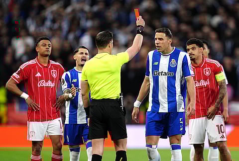 Porto's Jan Bednarek, center, is shown a red card and sent off by referee Danny Makkelie during the Europa League quarterfinal second leg soccer match between Nottingham Forest and Porto in Nottingham, England.