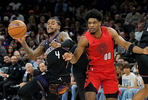 Phoenix Suns guard Jalen Green (4) drives past Portland Trail Blazers guard Scoot Henderson (00) during the second half of an NBA play-in tournament basketball game, in Phoenix.