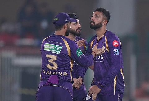Kolkata Knight Riders' Varun Chakaravarthy, right, celebrates with teammates the wicket of Gujarat Titans' Jos Buttler during the Indian Premier League cricket match between Gujarat Titans and Kolkata Knight Riders in Ahmedabad.