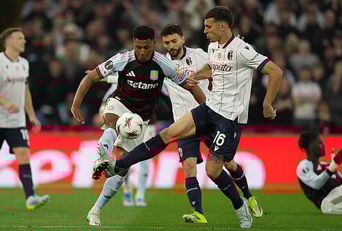 Aston Villa's Ollie Watkins, left, fights for a ball with Bologna's Nicolo Casale during the Europa League quarterfinal second leg soccer match between Aston Villa and Bologna, in Birmingham, England.