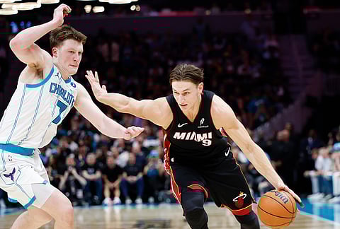 Miami Heat guard Pelle Larsson (9) drives against Charlotte Hornets guard Kon Knueppel during the second half of an NBA play-in tournament basketball game in Charlotte, North Carolina.