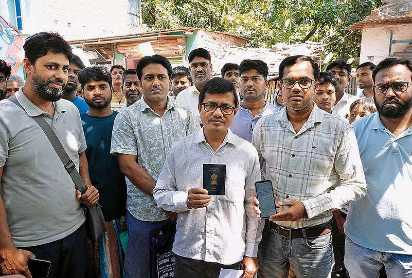 Md Abdul Malik (holding his passport), a primary school teacher
