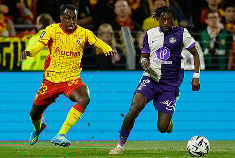 Lens' Saud Abdulhamid, left, and Toulouse's Warren Kamanzi fight for the ball during a League One soccer match between Lens and Toulouse in Lens, France.