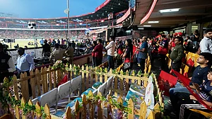 AP Photo/Aijaz Rahi) : Eleven seats are kept at M Chinnaswamy Stadium as a tribute to 11 Royal Challengers Bengaluru fans who lost their lives in a stampede last year, as spectators wait for the Indian Premier League cricket match between Royal Challengers Bengaluru and Sunrisers Hyderabad to begin, in Bengaluru, India, Saturday, March 28, 2026.