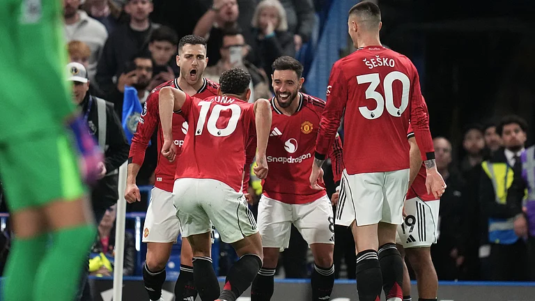 Manchester United's Matheus Cunha celebrates with teammates after scoring the opening goal during the English Premier League soccer match between Chelsea and Manchester United in London, Saturday, April 18, 2026. - (AP Photo/Kirsty Wigglesworth)
