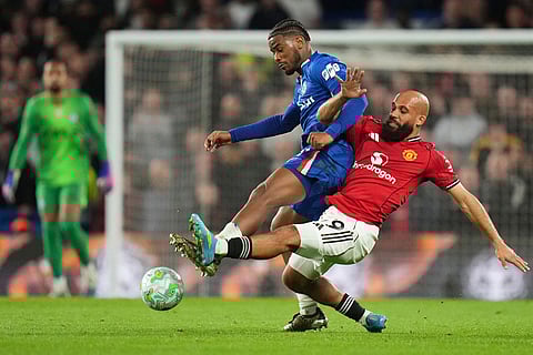 Chelsea's Jorrel Hato, top, and Manchester United's Bryan Mbeumo challenge for the ball during the English Premier League soccer match between Chelsea and Manchester United in London.
