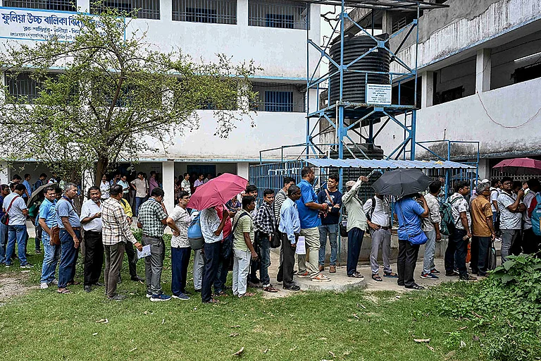 Polling officials wait in queues to cast their votes through postal ballots ahead of the West Bengal Assembly elections, in Phulia, Nadia district. - | Photo; PTI