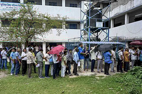 Polling officials wait in queues to cast their votes through postal ballots ahead of the West Bengal Assembly elections, in Phulia, Nadia district.