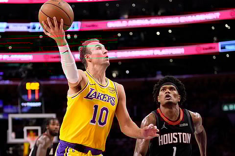 Los Angeles Lakers guard Luke Kennard, left, shoots as Houston Rockets guard Amen Thompson defends during the second half in Game 1 of a first-round NBA playoffs basketball series in Los Angeles.