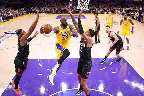 Los Angeles Lakers forward LeBron James, second from left, passes the ball as Houston Rockets guard Josh Okogie, left, and forward Jabari Smith Jr. defend during the first half in Game 1 of a first-round NBA playoffs basketball series in Los Angeles.